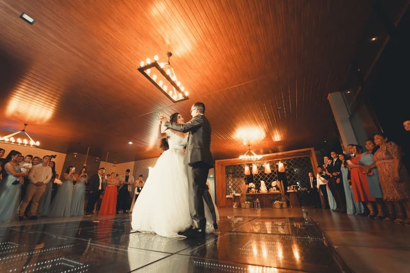 Bride and groom sharing a first dance in a warmly lit reception hall